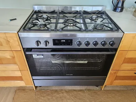The new kitchen with a freestanding gas cooker between timber drawers