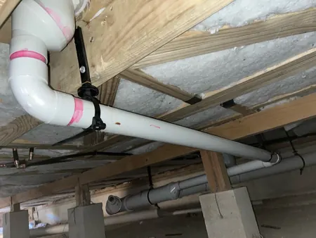 New waste pipework hung under the floor of C block