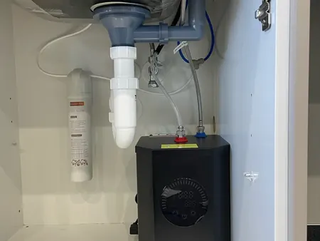 Finished under-sink plumbing with a water filter and hot water unit