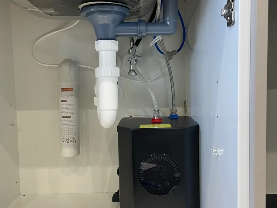 Finished under-sink plumbing with a water filter and hot water unit