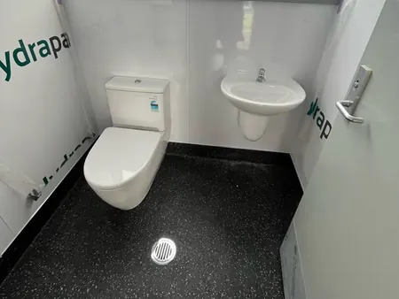 A finished toilet room with a new toilet, basin and floor waste