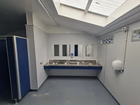 The same room finished, with new basins, mirrors, cubicles and flooring